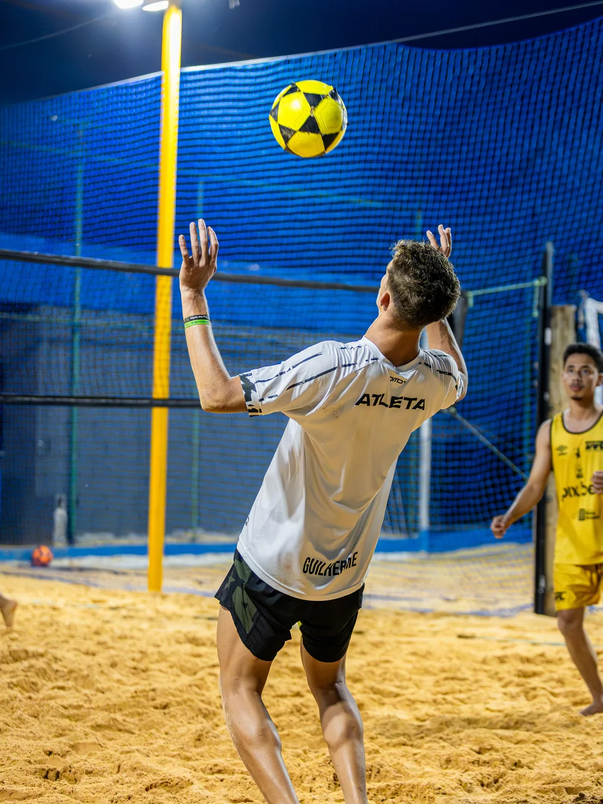 Jogador fazendo cabeçada no futevôlei na Orla Beach Center